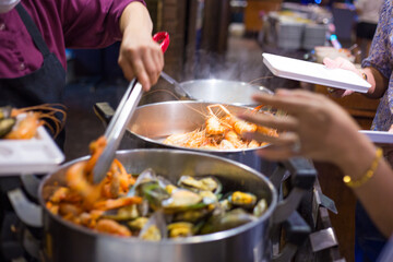 People hand take buffet food in hotel restuarant