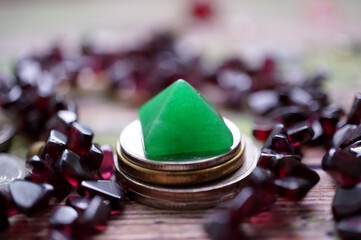 A small green pyramid with jewelry and coins.