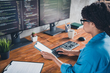 Photo of young woman typing keyboard hold device white screen wear blue shirt modern office...
