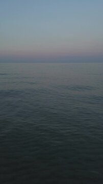 Wellen erreichen einen Sandstrand auf Korsika bei Sonnenuntergang