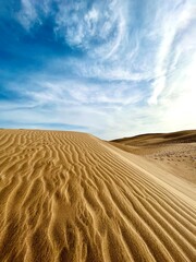 Minimalist photography of golden dunes against a bright blue sky next to the ocean. Dunas Maspalomas Gran Canaria, Spain