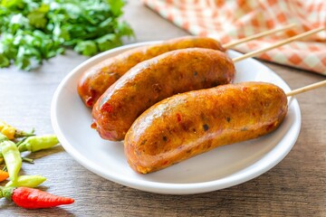Northern Thai Sausage in a white plate on wooden background, thai called Sai Oua