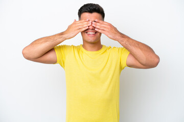 Young caucasian handsome man isolated on white background covering eyes by hands and smiling