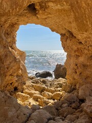 view through a cave to the sea with sun and blue sky, vacation mode