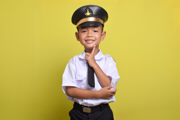 Little Asian boy Airplane pilot isolated on yellow background with cute pose and smile. Little boy dreams of becoming an airplane pilot. © Mulad Images