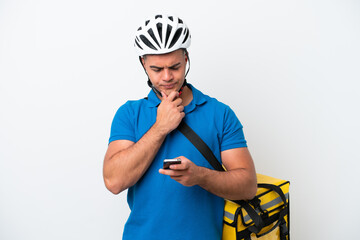 Young caucasian man with thermal backpack isolated on white background thinking and sending a message