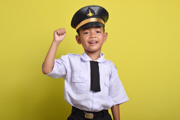 Little Asian boy Airplane pilot isolated on yellow background celebrating a victory in winner position. Little boy dreams of becoming an airplane pilot.
