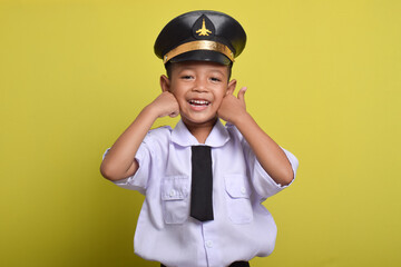 Little Asian boy Airplane pilot isolated on yellow background with thumbs up gesture and smile. Little boy dreams of becoming an airplane pilot