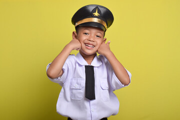 Little Asian boy Airplane pilot isolated on yellow background with thumbs up gesture and smile. Little boy dreams of becoming an airplane pilot