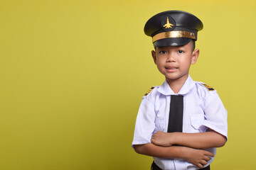 Little Asian boy Airplane pilot isolated on yellow background with crossed arms and looking forward. Little boy dreams of becoming an airplane pilot.
