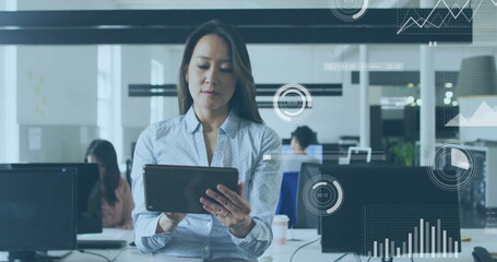 Image of financial data processing over biracial businesswoman using tablet in office