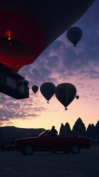 hot air balloon adventure at sunrise with a convertible car in cappadocia, turkey