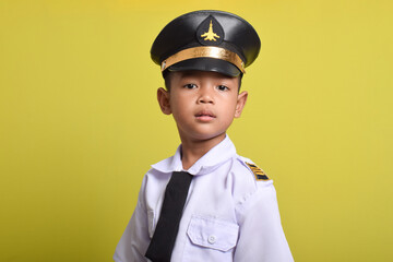 Little Asian boy Airplane pilot isolated on yellow background. Little boy dreams of becoming an airplane pilot.