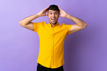 Young Colombian man isolated on purple background with surprise expression