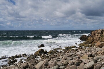 Wellen brechen am Strand Solviken in Mölle auf der Halbinsel Kullen im Öresund an einem stürmischen Sommertag. Kullen liegt in Südschweden.