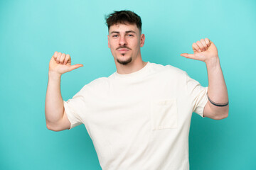 Young caucasian handsome man isolated on blue background proud and self-satisfied