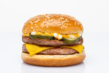Double burger with pork patty, cheddar cheese, pickled cucumber, onion and burger sauce on white background