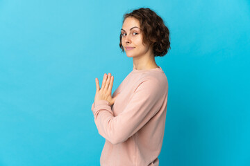 Young English woman isolated on blue background scheming something