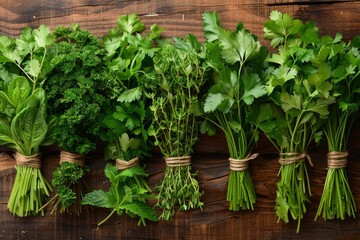 Fresh herbs, including parsley, mint, and thyme, arranged on a rustic wooden background.