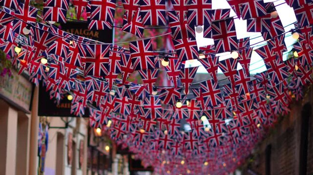 Garland of British flags on a street during UK celebration, festive atmosphere. - Powered by Adobe