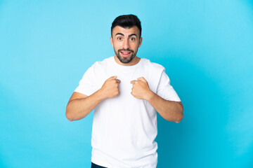 Caucasian man over isolated blue background with surprise facial expression