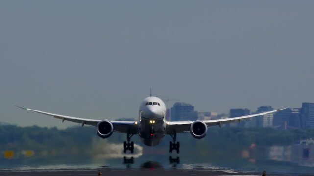 A passenger plane lifting off the runway, with a city skyline in the background under a clear sky