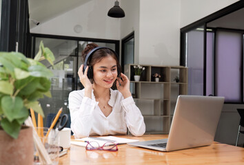 Young Businesswoman in White Shirt Having an Online Meeting with Headphones in Modern Office Setting