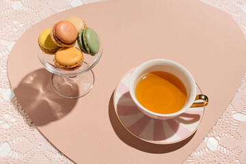 A cup of tea and fruit flavored macarons.