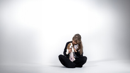 World animal day, friendship between a woman and a dog. A young fair-skinned woman holds a beagle in her arms. Vertical photo with empty space.