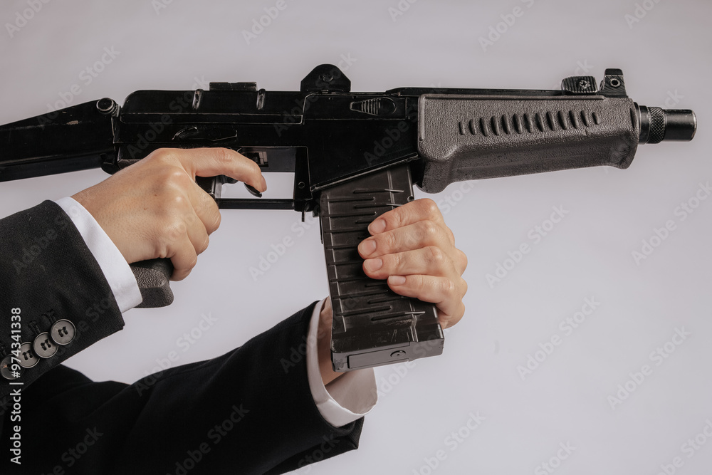 Wall mural a close-up shot of a hand gripping the front handle of a black submachine gun, showcasing details of