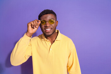 Photo portrait of pretty young male touch eyewear wear trendy yellow outfit isolated on purple color background