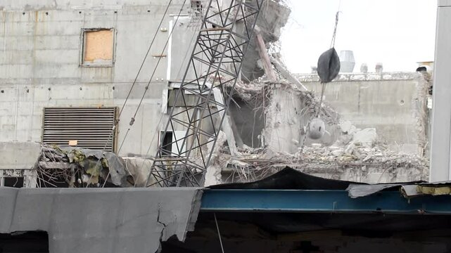 Wrecking ball being used for demolition of concrete building