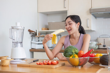 Healthy Young Woman Preparing Fresh Juice in a Modern Kitchen with Fresh Vegetables and Fruits