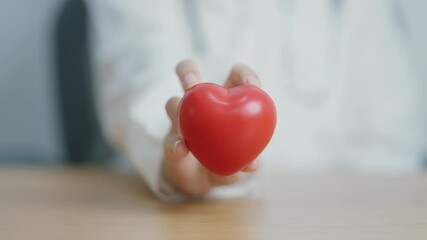 Doctor hand holding red heart shape in hospital. love, donor, world heart day, world health day, CSR donation and Insurance concepts