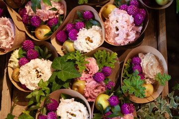 Beautifully arranged bouquets featuring pink and purple flowers, apples, and lush green leaves in rustic paper wraps