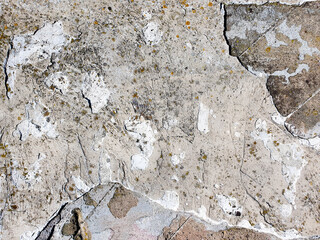 Old dilapidated cement plaster surface. A crumbling wall, a building. A damaged cement plaster surface