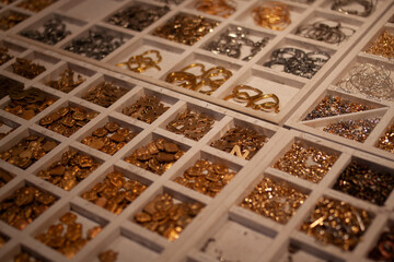 Collection of Vintage Brass, Silver, and Metal Trinkets Displayed Neatly in Divided Sections with a Rustic Touch