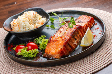 Salmon steak with creamy rice. A succulent salmon fillet, perfectly grilled or pan-seared, served alongside a bed of rich, creamy rice.