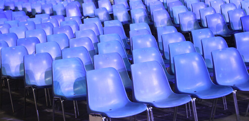 Fototapeta premium empty blue plastic chairs without people before the start of a live concert