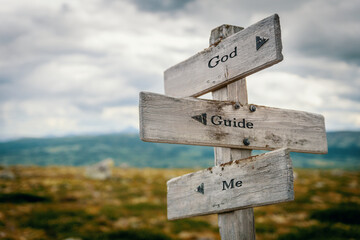 god guide me text quote on wooden directional signpost outdoors in nature