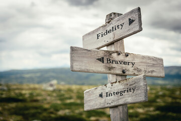 fidelity bravery integrity text quote on wooden directional signpost outdoors in nature