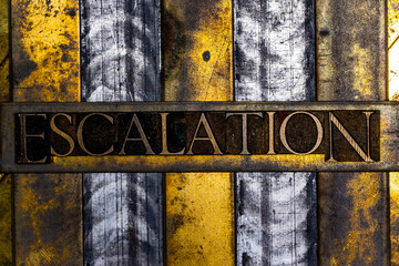 Escalation text in real authentic typeset letters on vintage textured silver grunge copper and gold background
