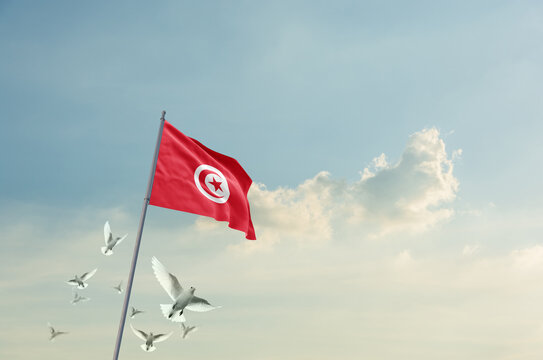 Tunisia flag waving with flying doves in beautiful sky. Tunisia flag for Republic Day and Independence Day.