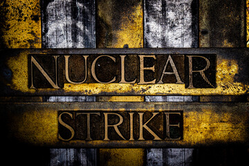 Nuclear Strike text in real authentic typeset letters on vintage textured silver grunge copper and gold background