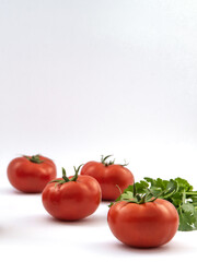 Tomato and parsley on a white background. Selective focus.