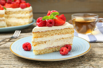 Piece of tasty sponge cake with fresh berries and mint on wooden table, closeup