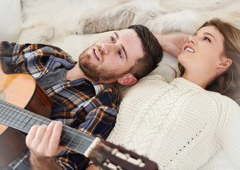 Happy couple, home and playing guitar for love, together and relationship with joy, support or care Woman, man and music instrument for bonding, relax and fun in lounge for session, peace and memory