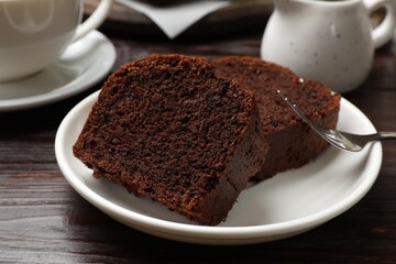 Slices of delicious chocolate sponge cake on wooden table, closeup