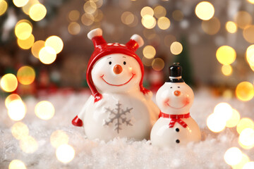 Cute snowman figures in Christmas composition, bokeh effect