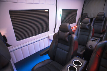 Comfortable interior of a passenger bus with soft seats. The design is made to order. Private...